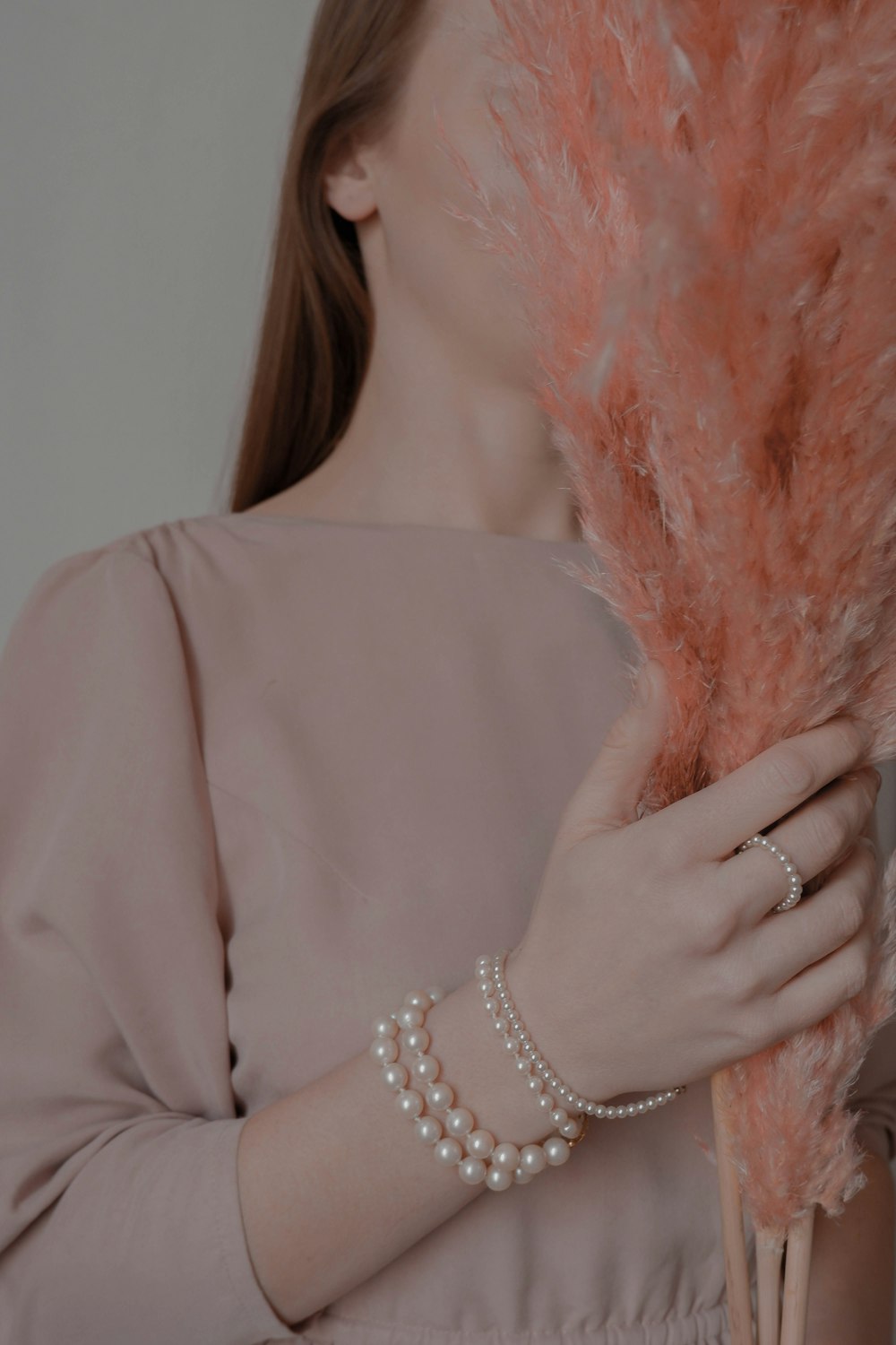 woman wearing champagne color dress holding artificial flower