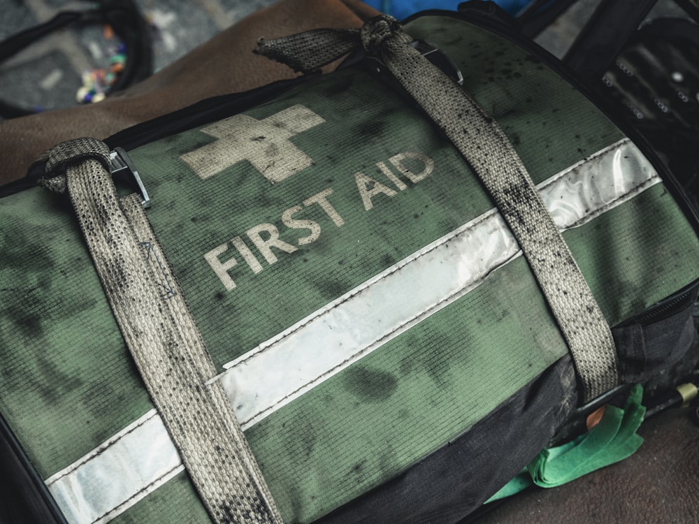 green and black first aid bag