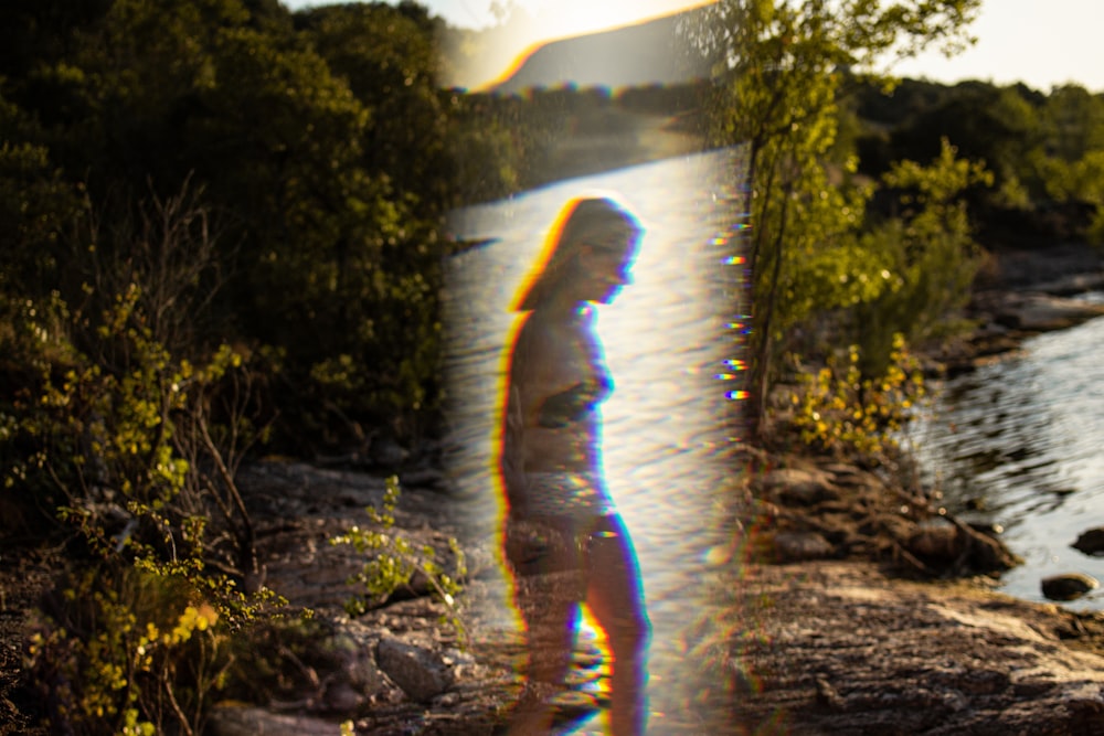 a man standing on a beach next to a body of water