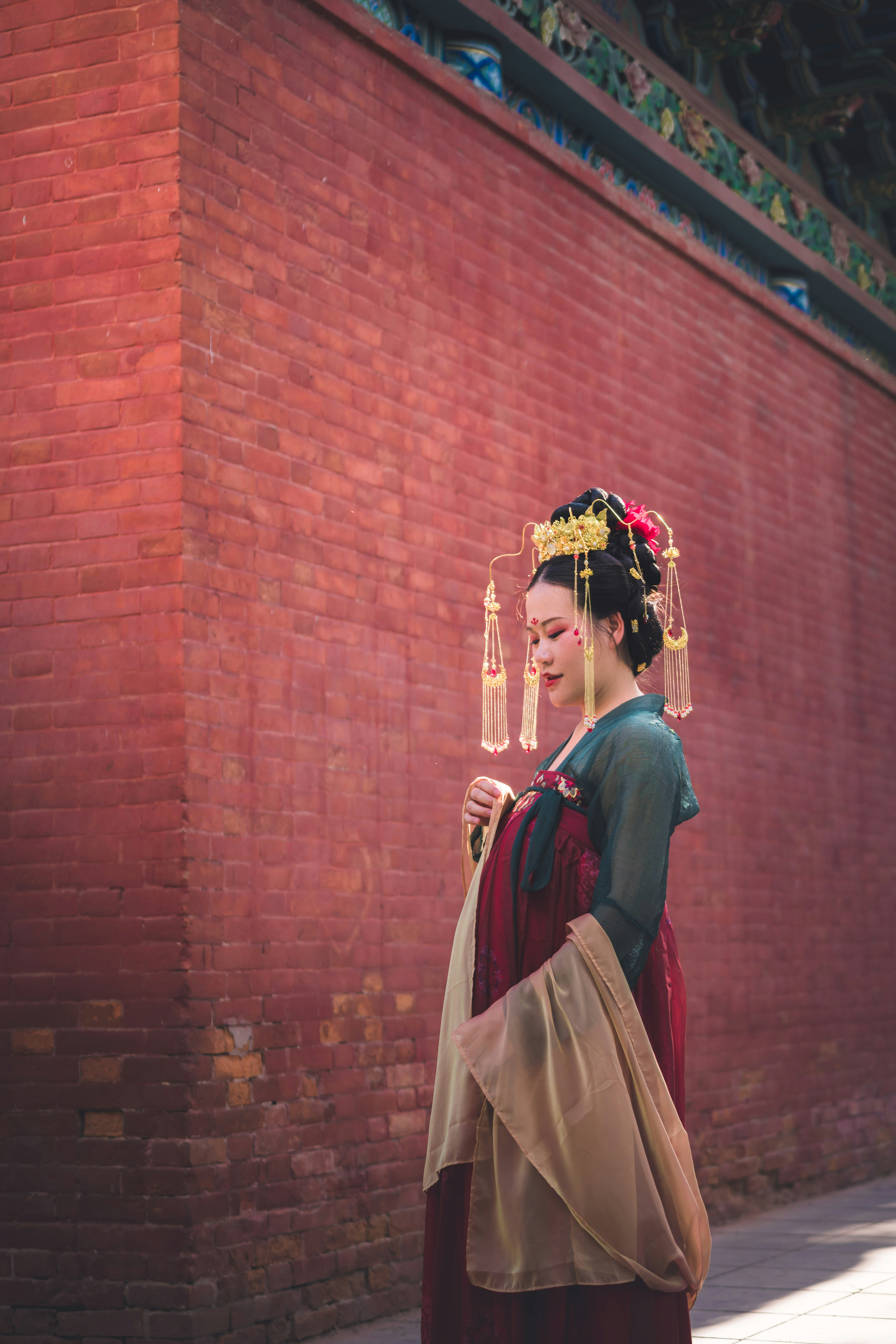 Una mujer con un vestido tradicional chino está parada frente a una pared  de ladrillos foto – Imagen de Moda gratuita en Unsplash, image size:3000x4498