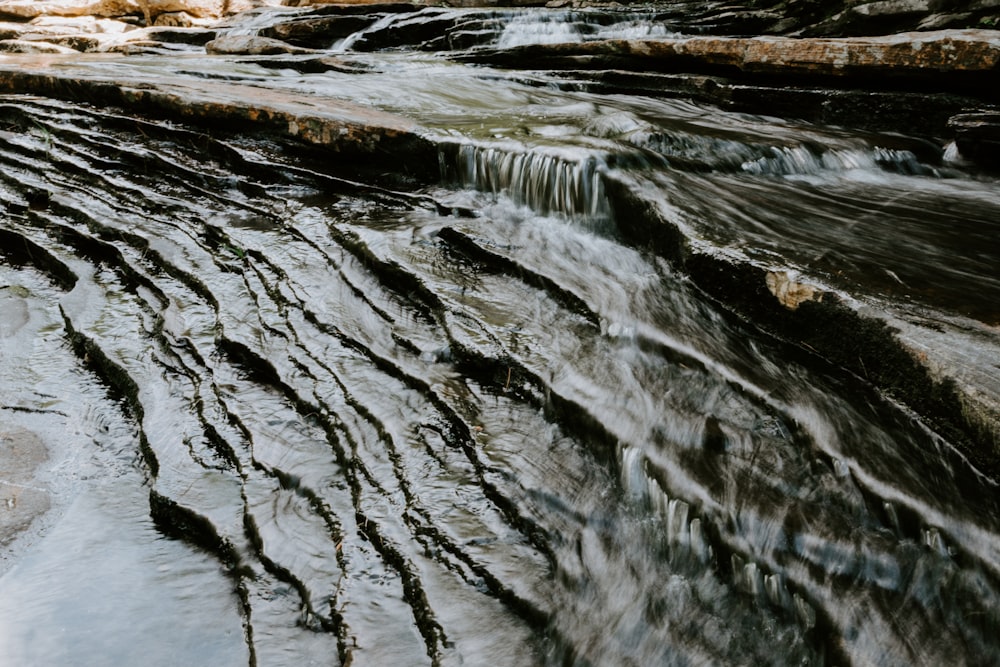a stream of water flowing down a rocky hillside