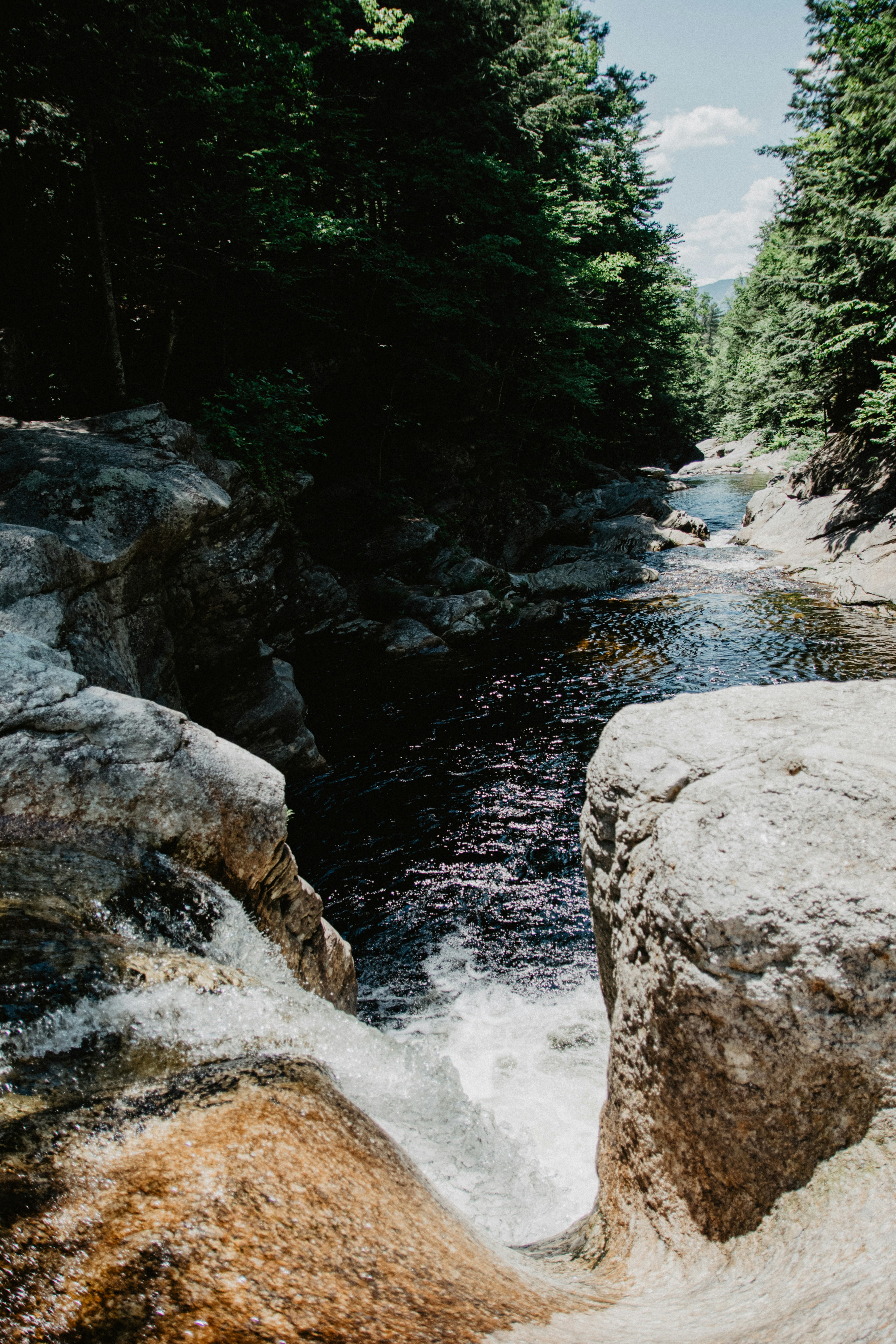 waterfall between trees during daytime