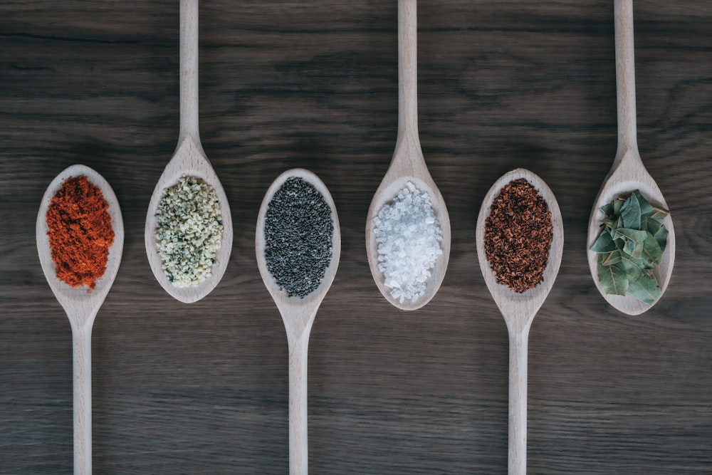 assorted-color spoons with spices