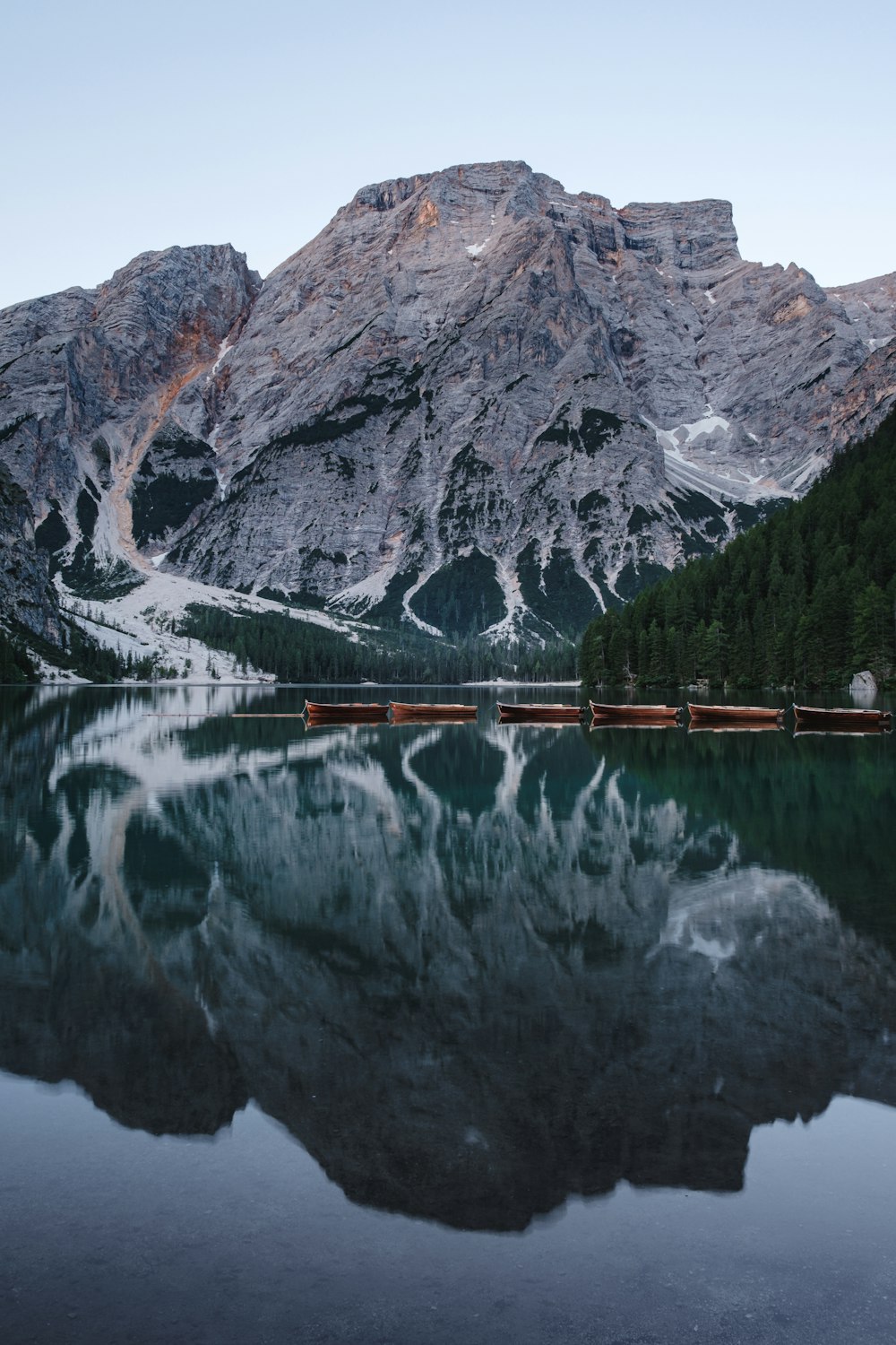 grey cliff beside calm body of water