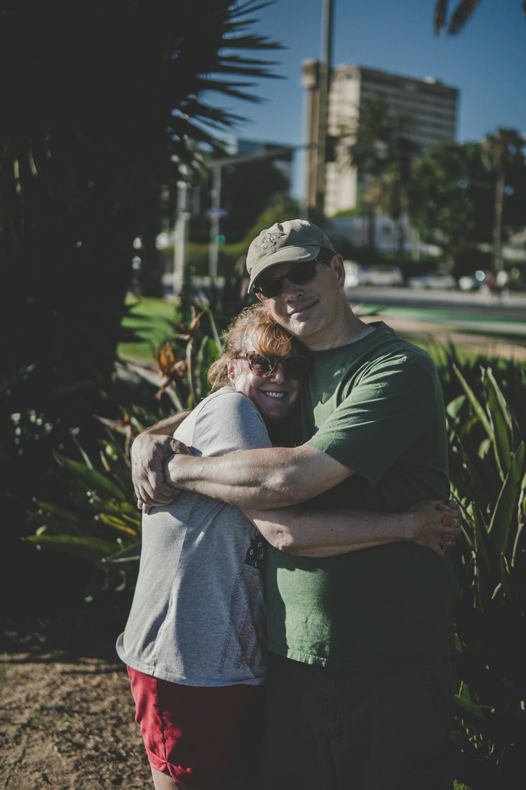 man and woman hugging near buildings