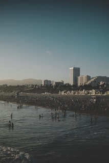 A panoramic shot of Busan's Haeundae Beach crowded with visitors on a sunny day.