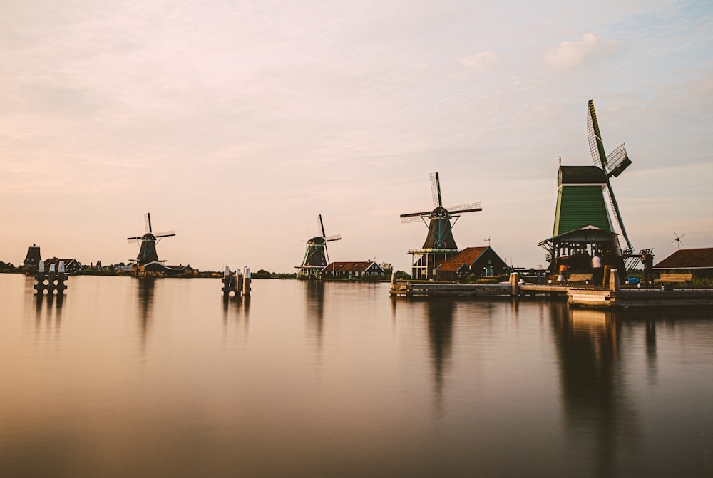 a group of windmills sitting on top of a lake