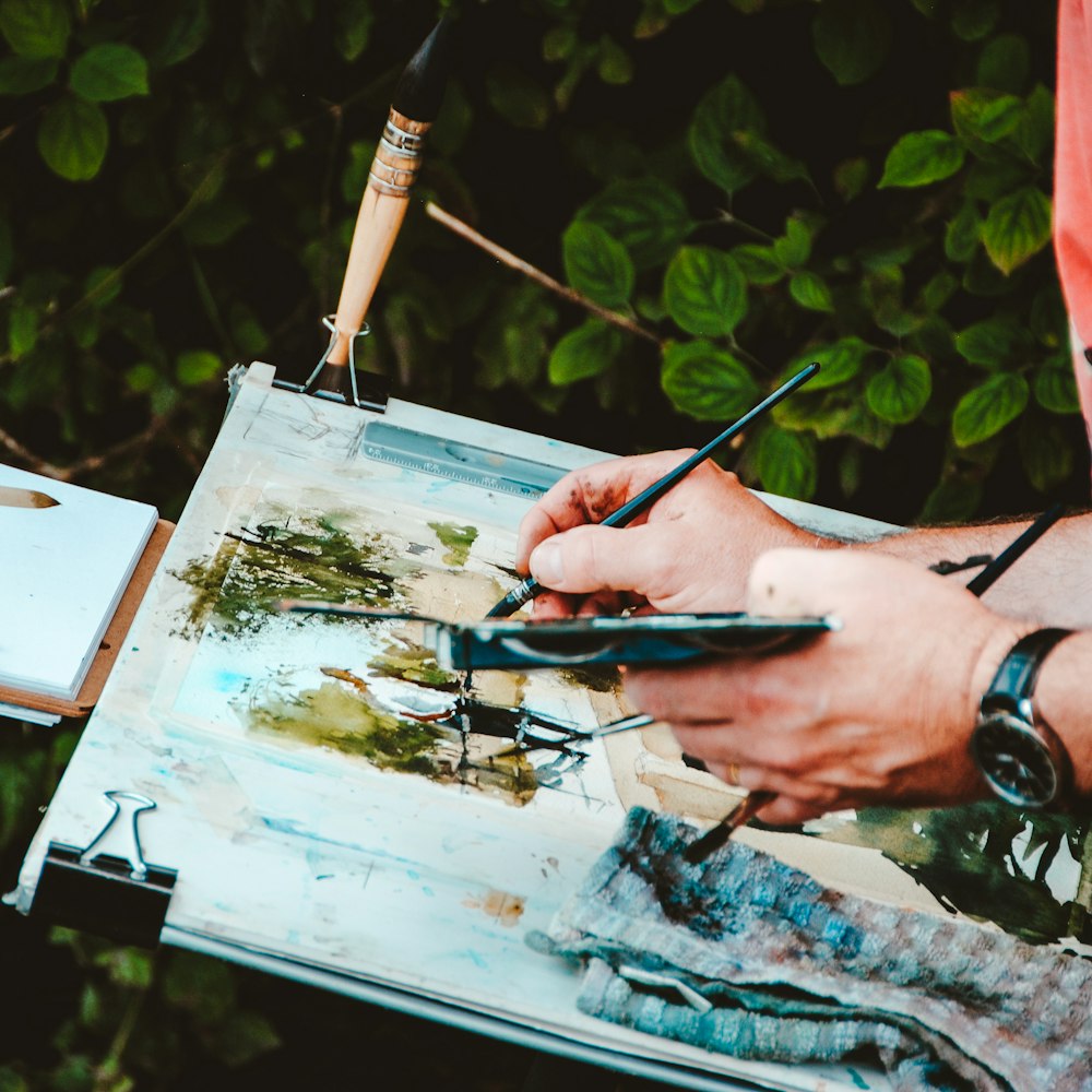 person painting chair and green trees