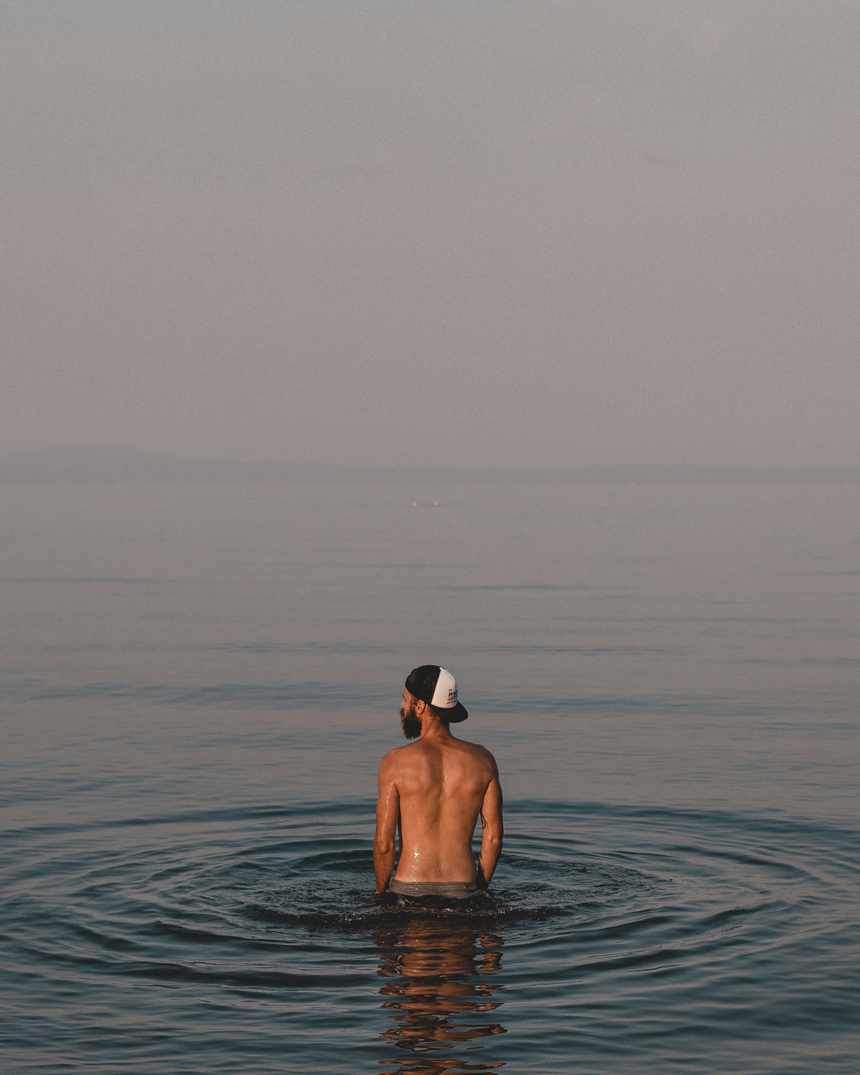 topless man on body of water during daytime