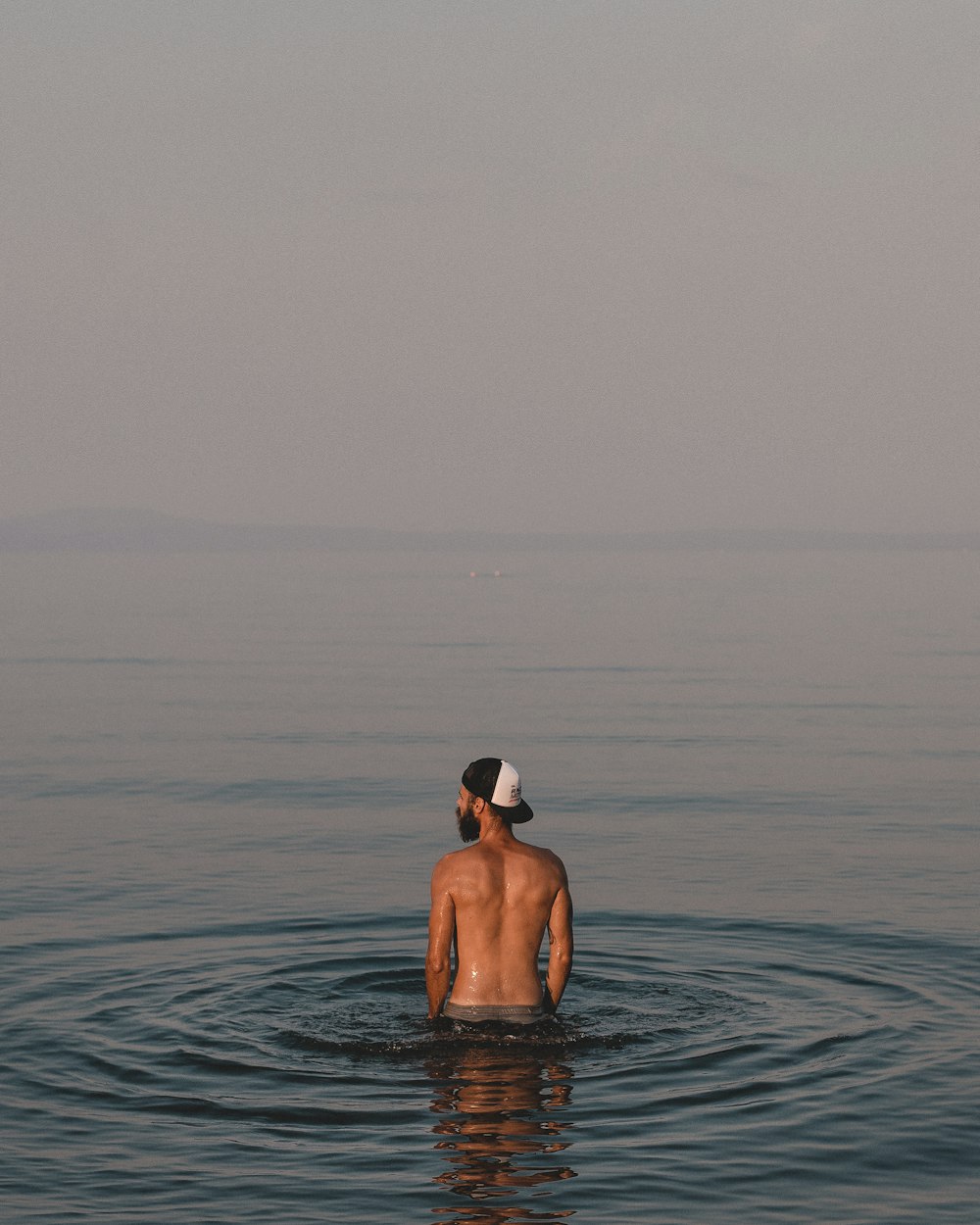 topless man on body of water during daytime