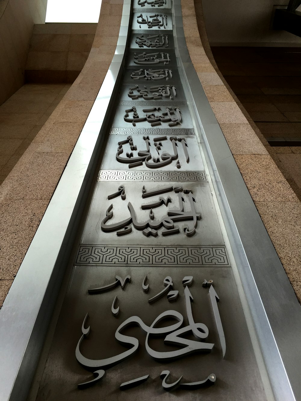 a metal sign with arabic writing on it