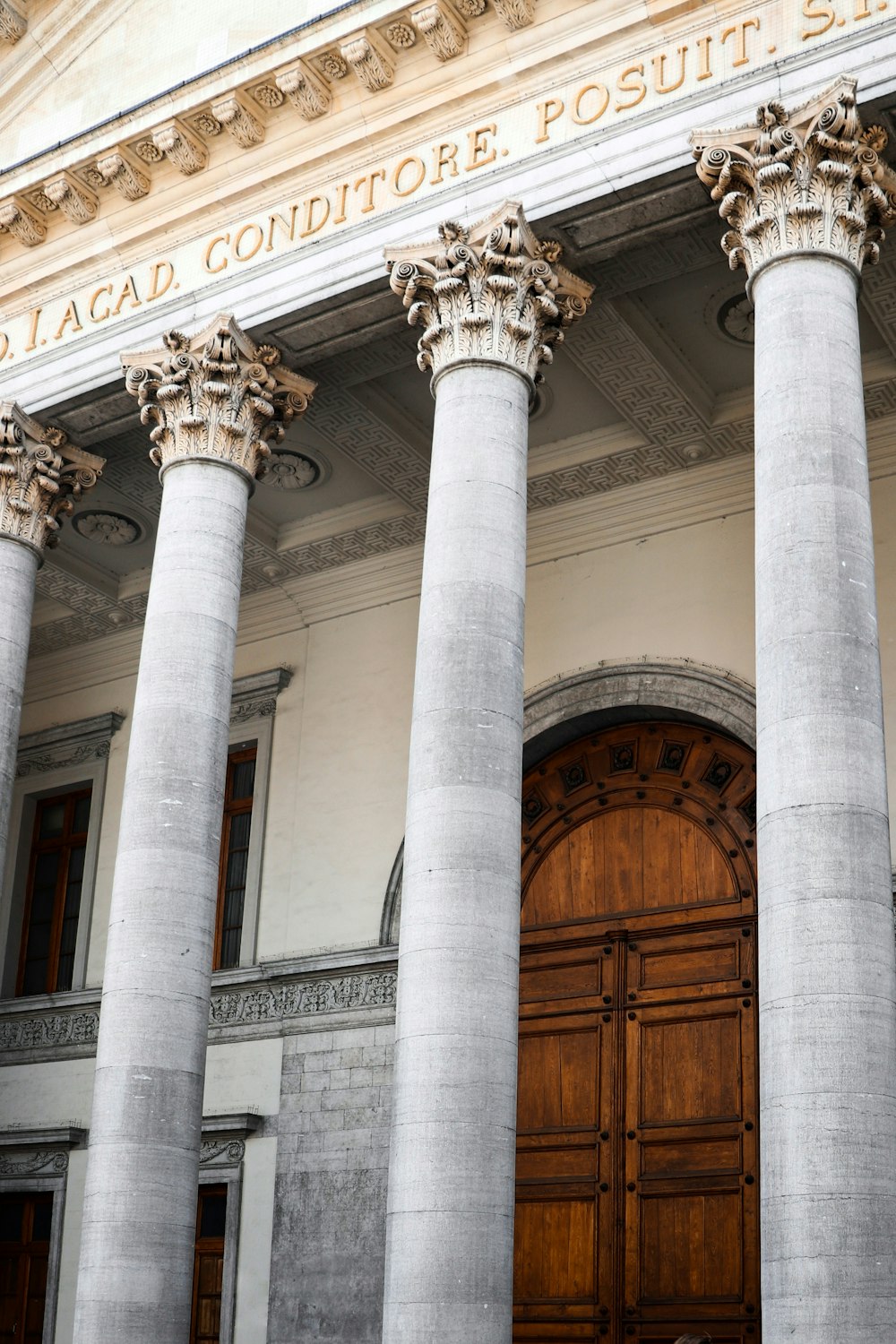 a large building with four pillars and a wooden door