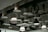 A ceiling with an industrial design featuring various hanging light fixtures and exposed ductwork. The ducts are covered with a textured material, and there are also black metal pulleys and hooks accentuating the design.