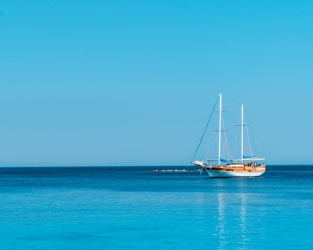 barco no corpo de água sob o céu azul durante o dia