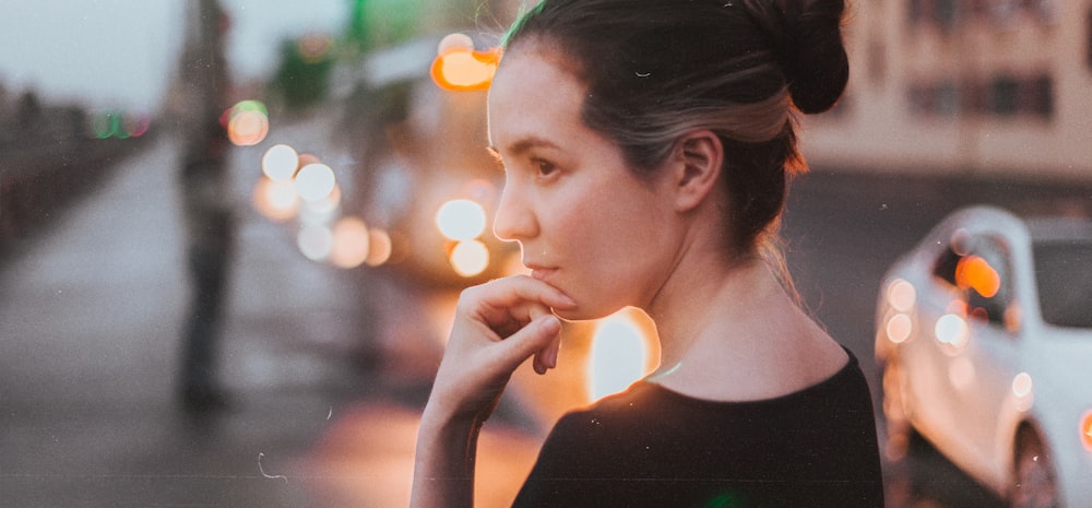 a woman standing on a city street at night