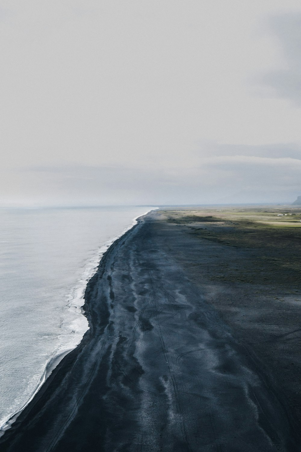 body of water under white sky at daytime