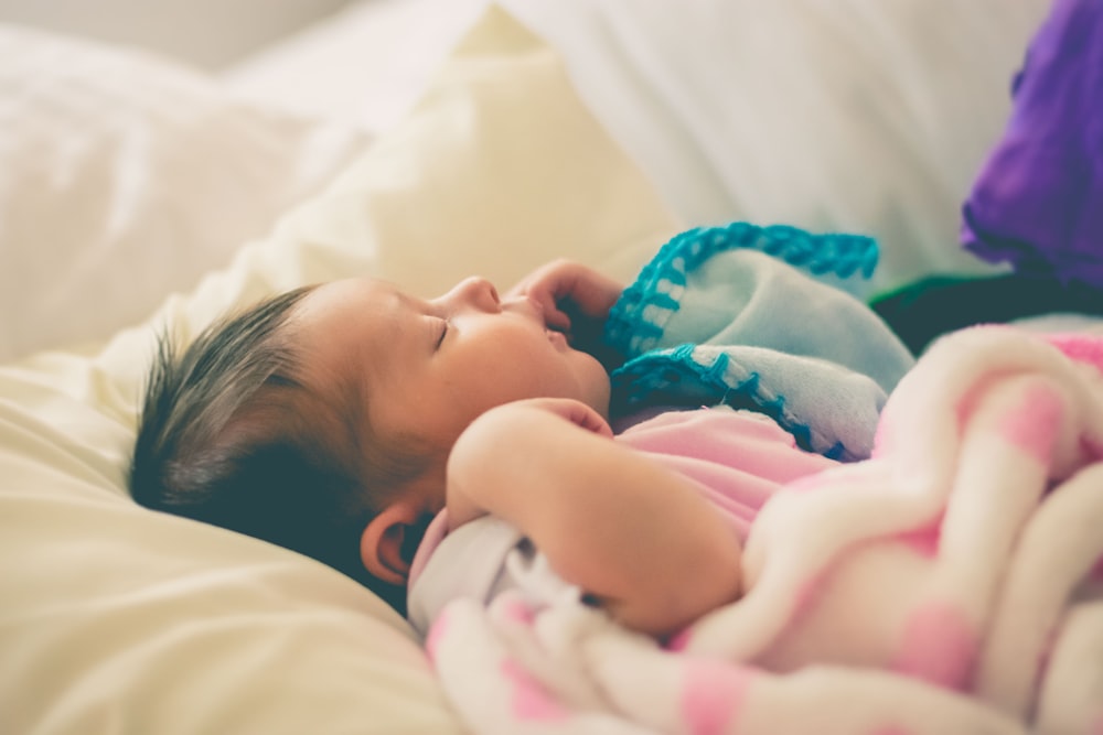 baby sleeping on bed