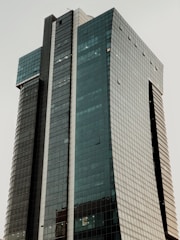 A sleek commercial office tower with glass facade.