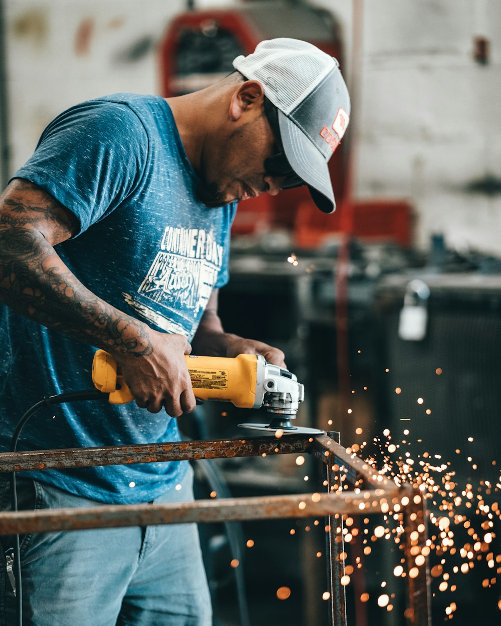 shallow focus photo of man using angle grinder
