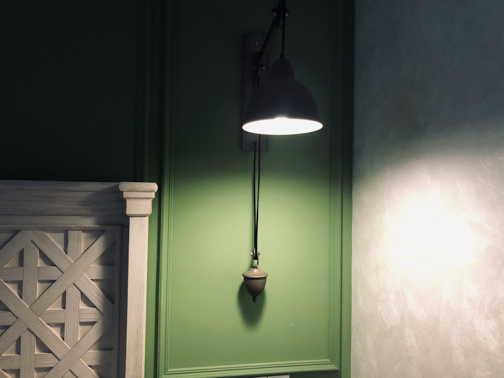 black and green sconce turned-on