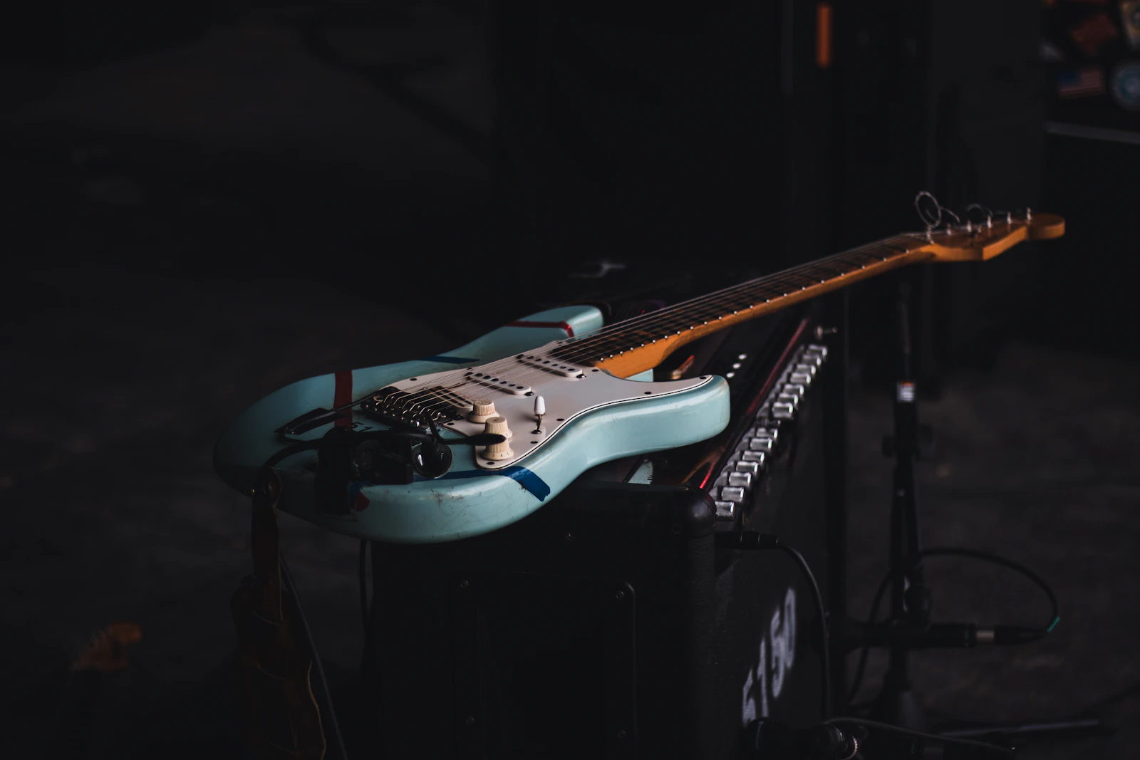 A guitar effects pedal on a dark studio desk.