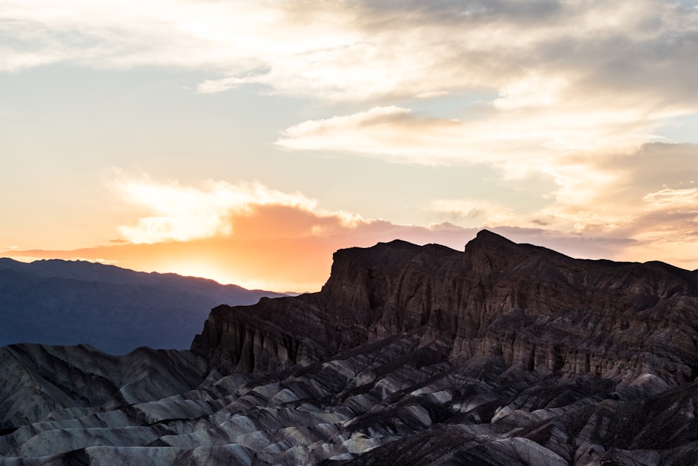 the sun is setting over a mountain range