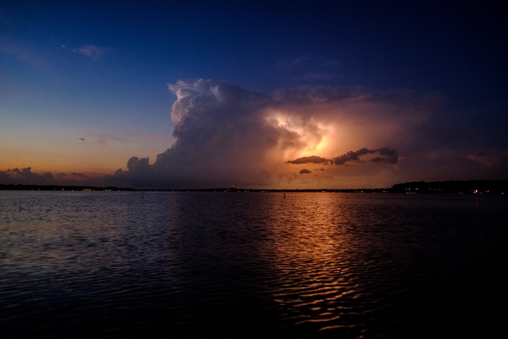 Specchio d'acqua sotto il cielo blu e bianco all'ora d'oro