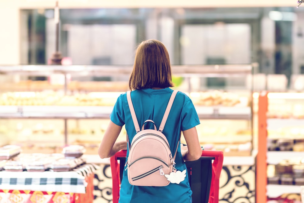 woman with pink backpack standing outdoor during daytime