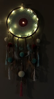 A dark fantasy-inspired wall hanging with embroidered forest animals and plants, illuminated by subtle lighting.