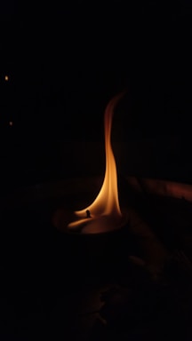 A gentle candle flame flickering softly in a quiet chapel.