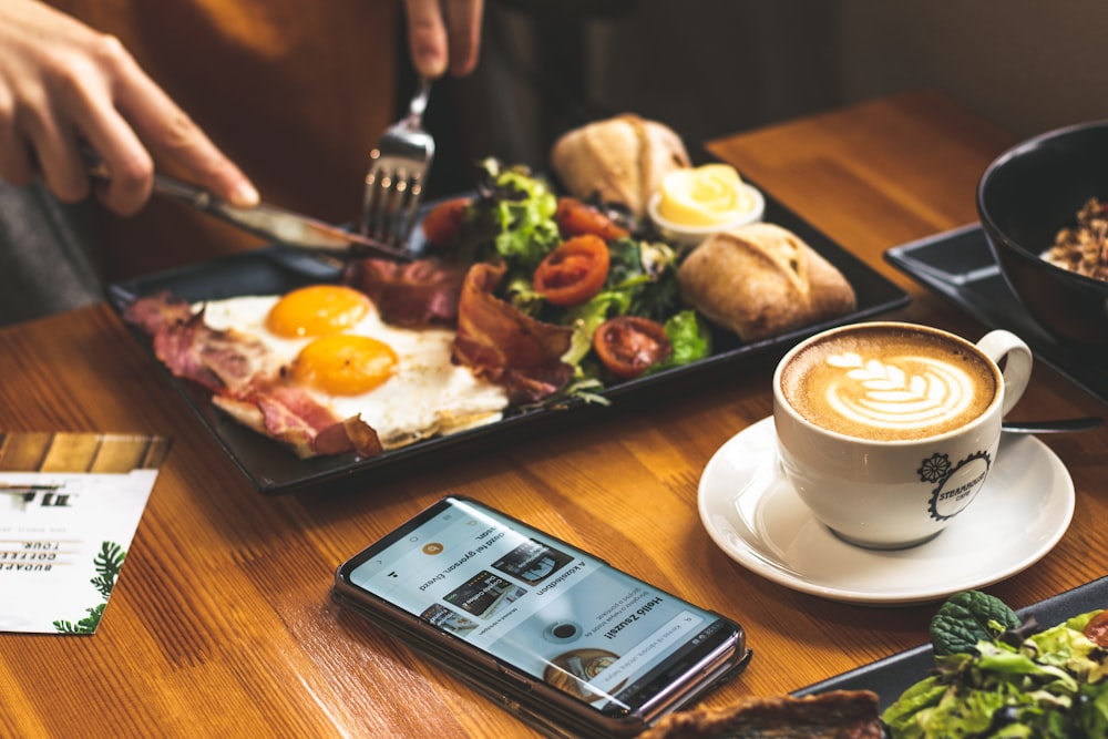 uomo seduto davanti al tavolo con la colazione servita