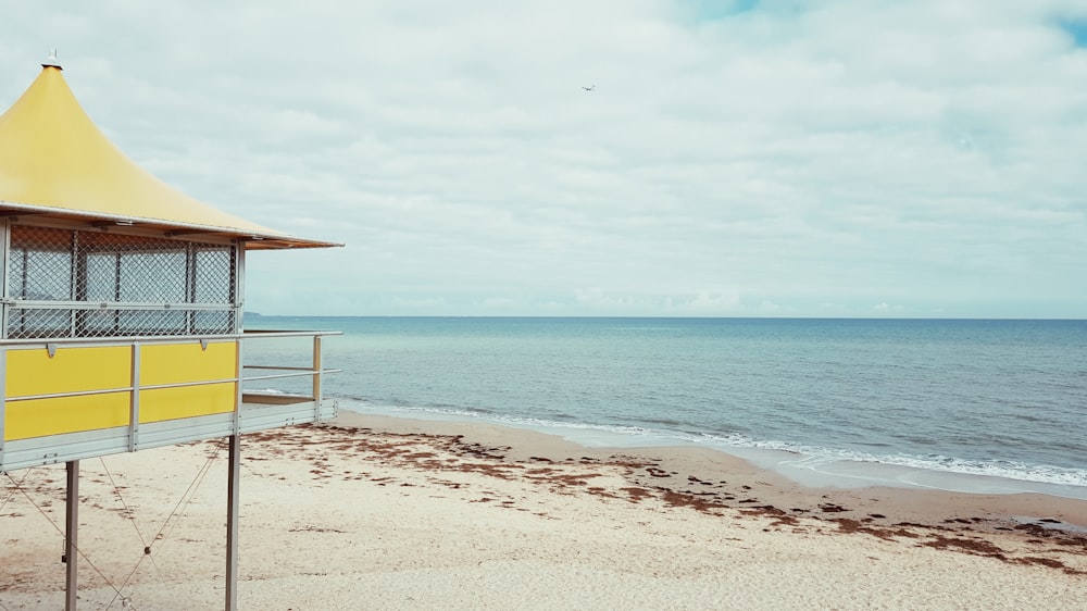 Casa de campo de madeira amarela e branca na praia