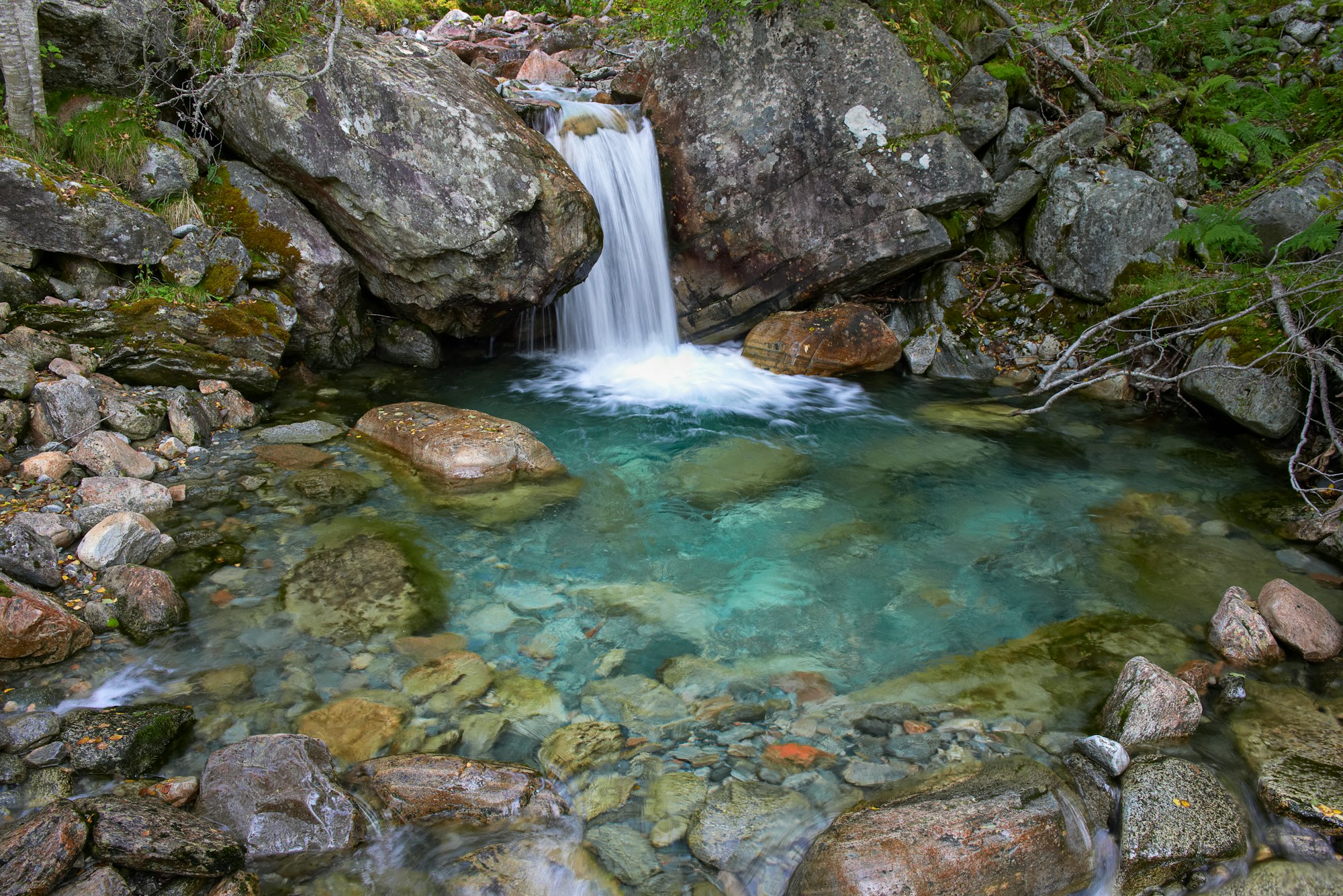 long exposure of a small waterfall with blue water