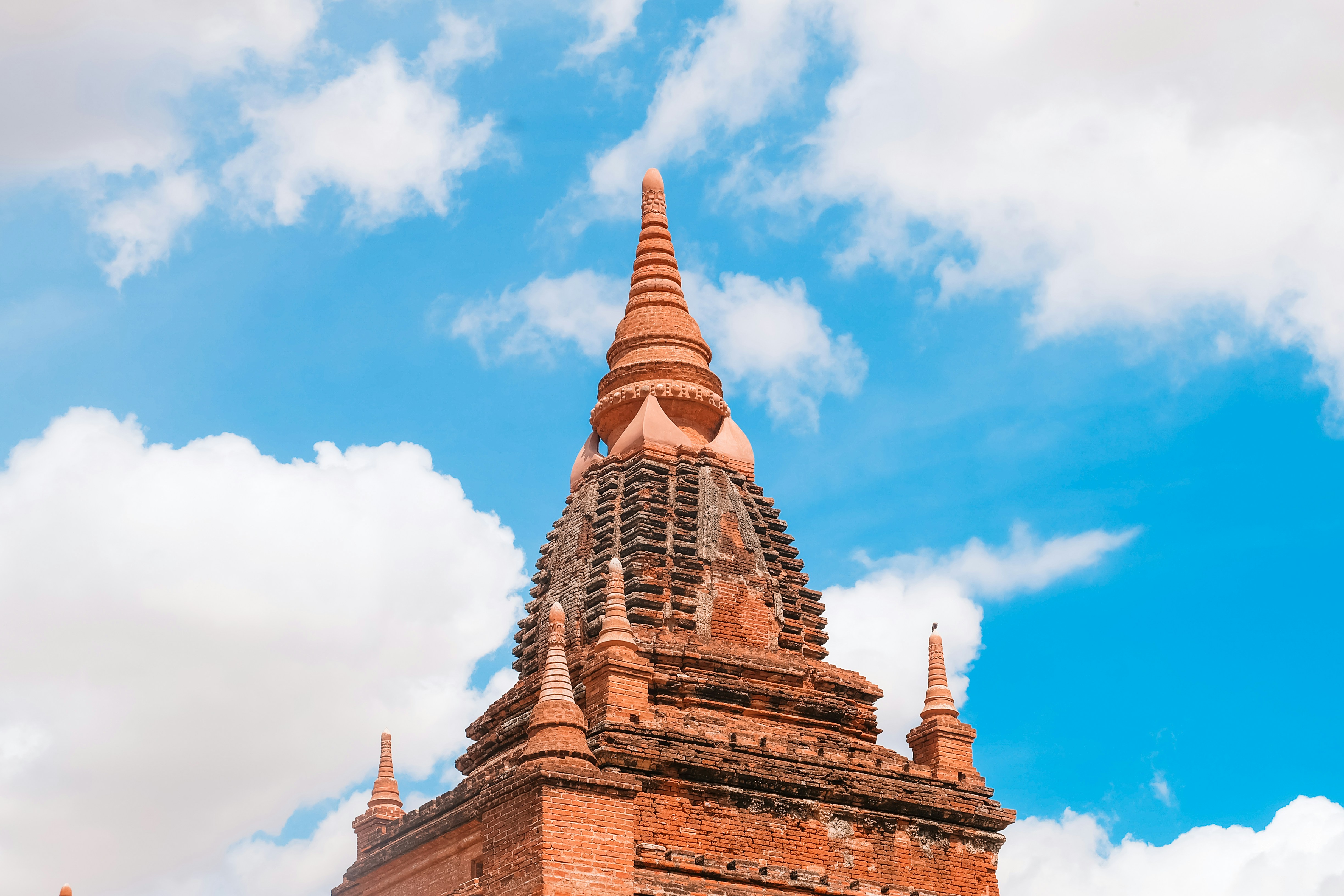 Edificio de hormigón marrón bajo el cielo azul y blanco durante el día