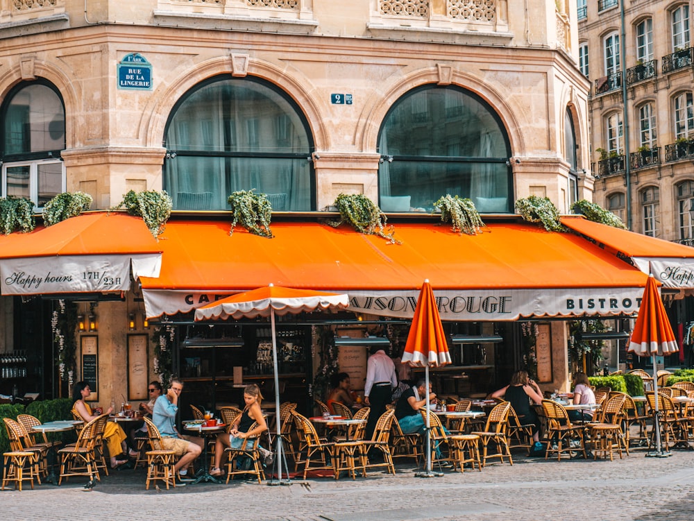 people sitting on chair beside building and road during daytime