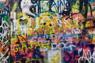 a wall covered in lots of colorful graffiti