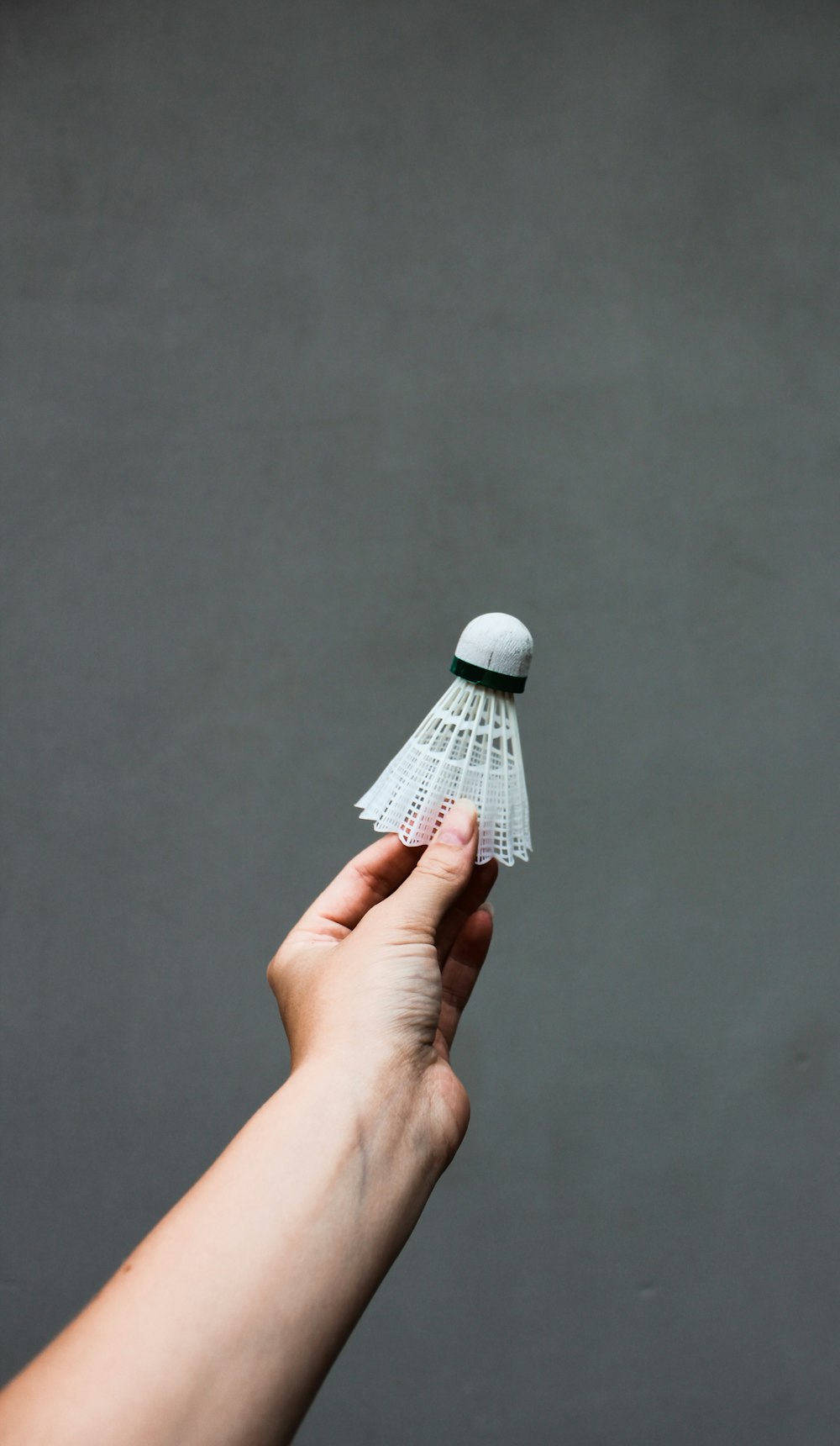 person holding white shuttlecock