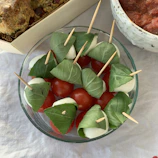Colorful caponata overflowing from a terracotta bowl with fresh bread.