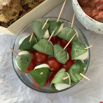 Tomato sauce in a bowl with fresh tomatoes around it.