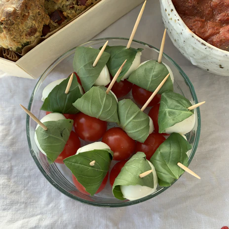 Freshly baked garlic bread sticks arranged neatly beside a bowl of marinara sauce.