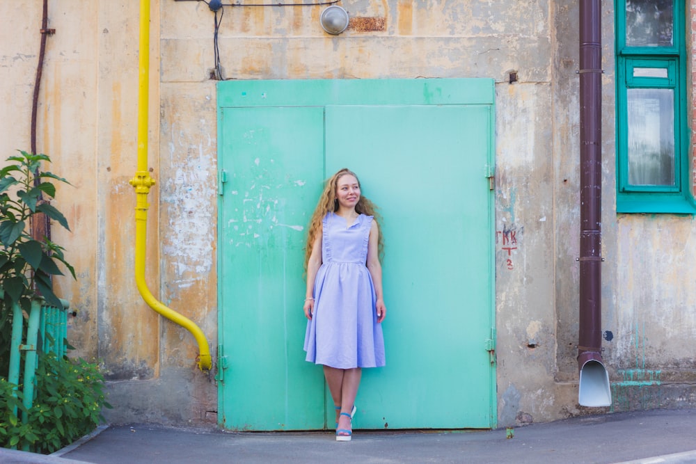 woman standing against teal door