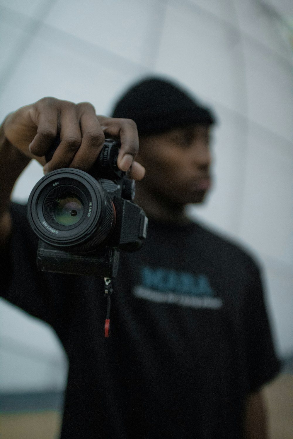 man holding black DSLR camera
