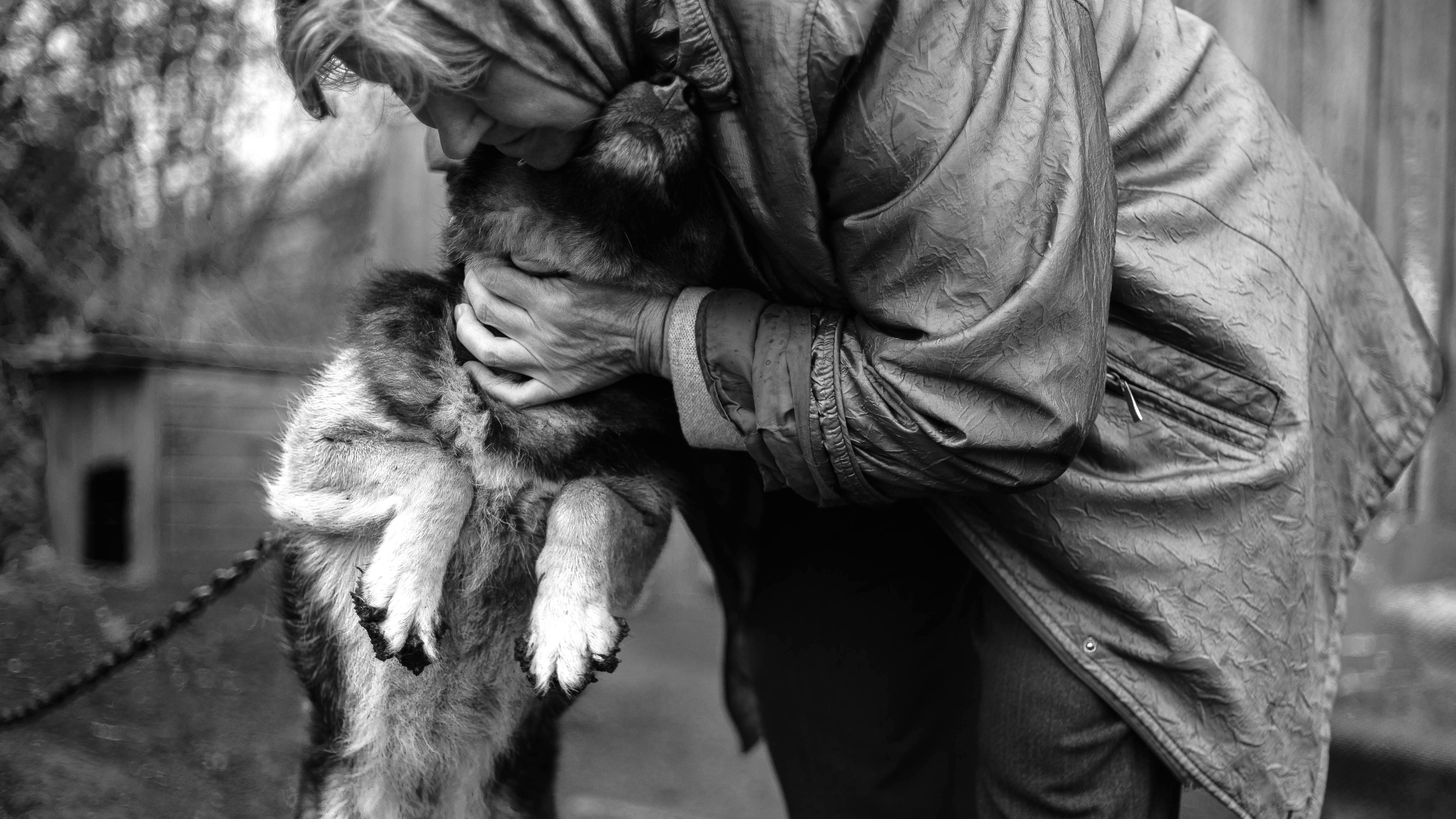 grayscale photography of woman hugging dog