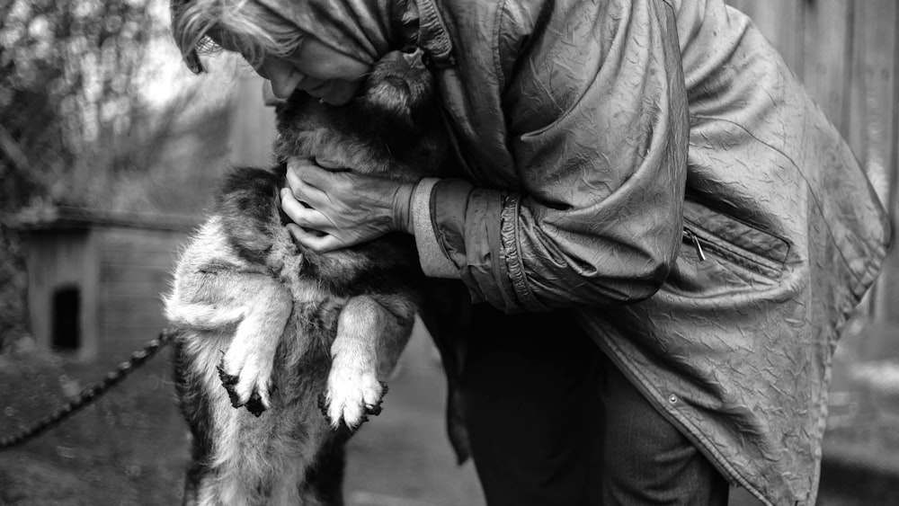 grayscale photography of woman hugging dog