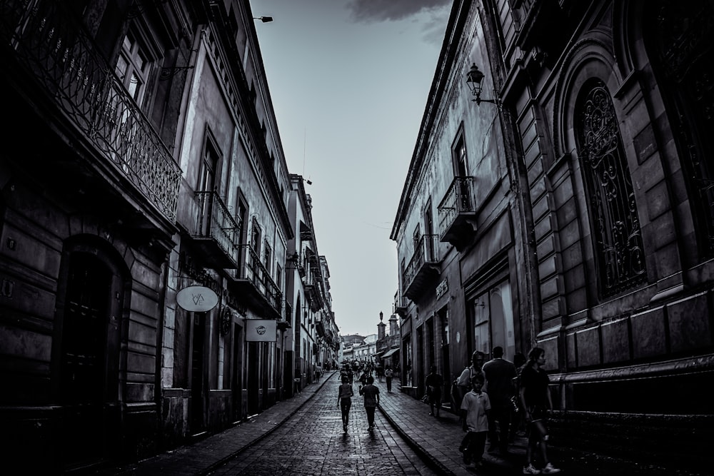 greyscale photo of people walking on street