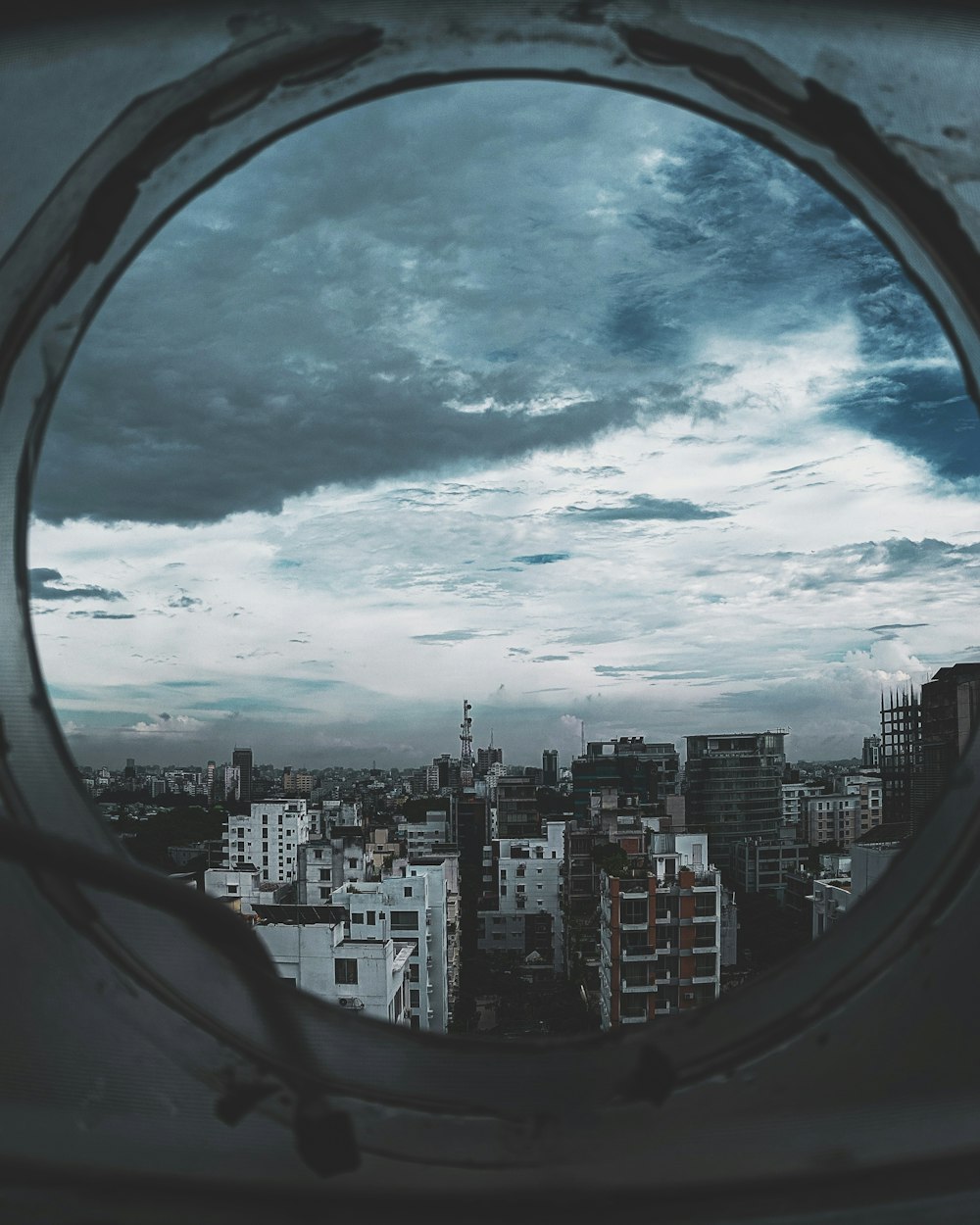 city buildings across white clouds