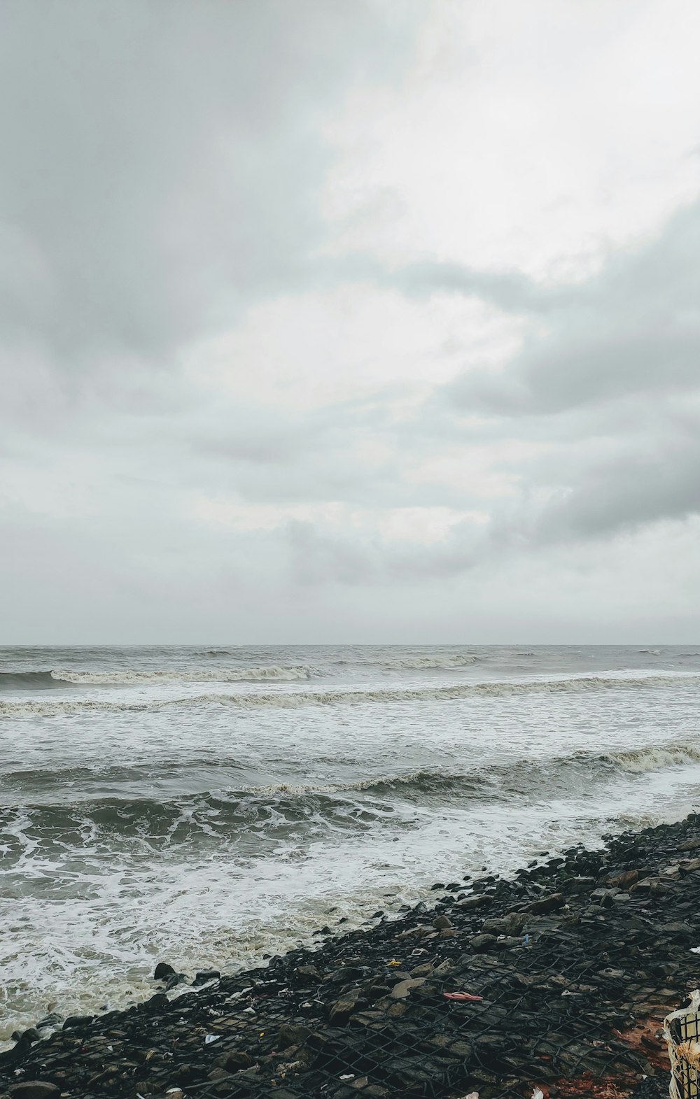 Eine Person, die an einem felsigen Strand neben dem Meer steht