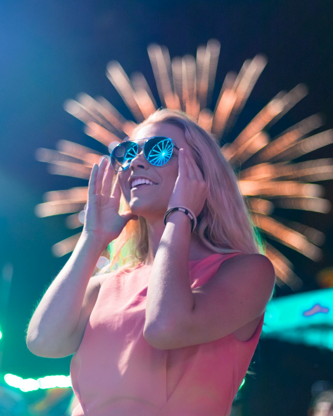 woman wearing sunglasses looking on fireworks during night time