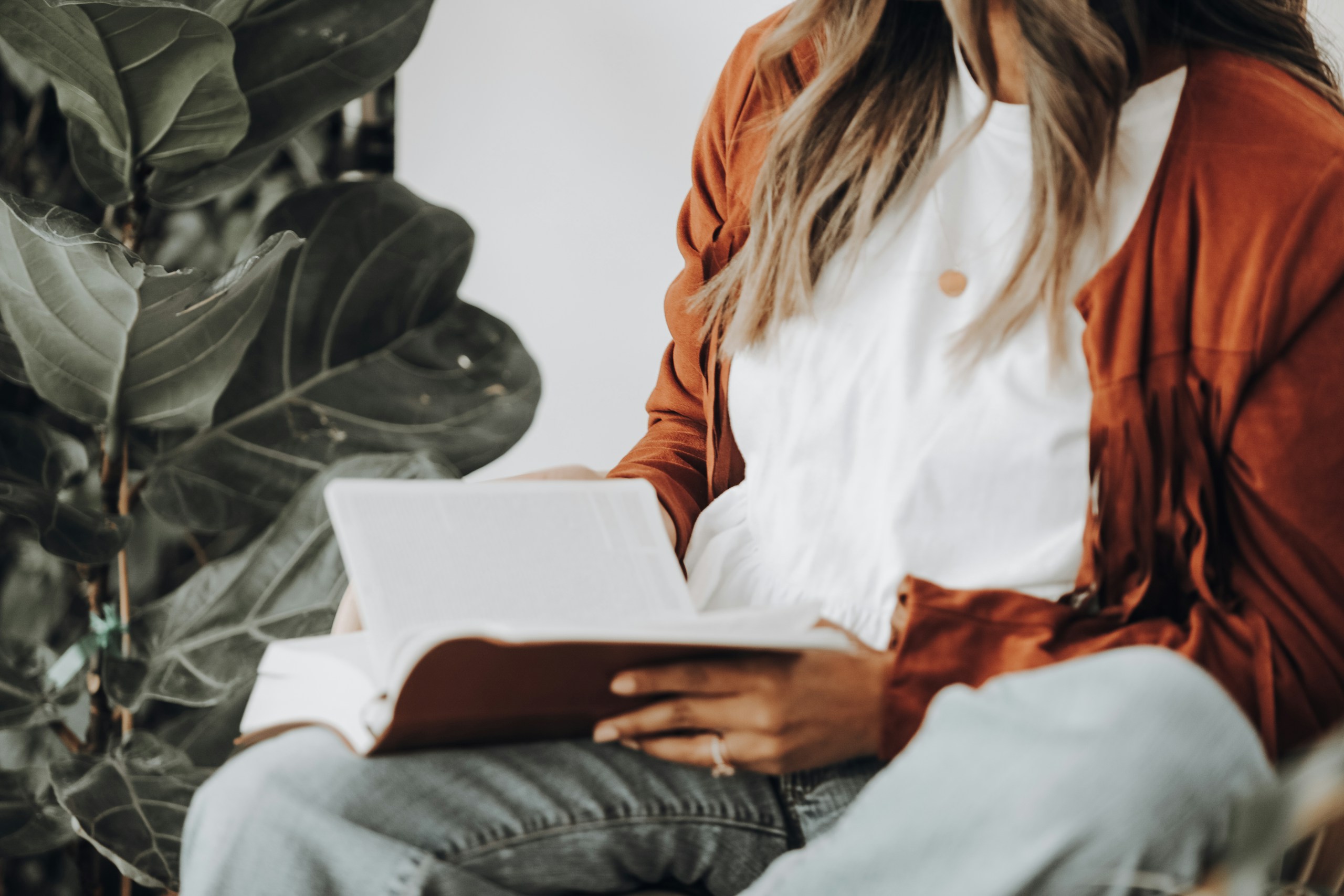 a photo of a woman wearing a brown leather jacket reading