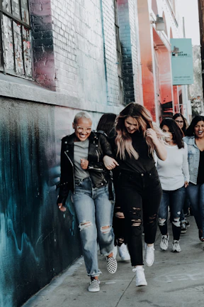 A group of diverse walkers sharing smiles mid-stride on a leafy neighborhood path.